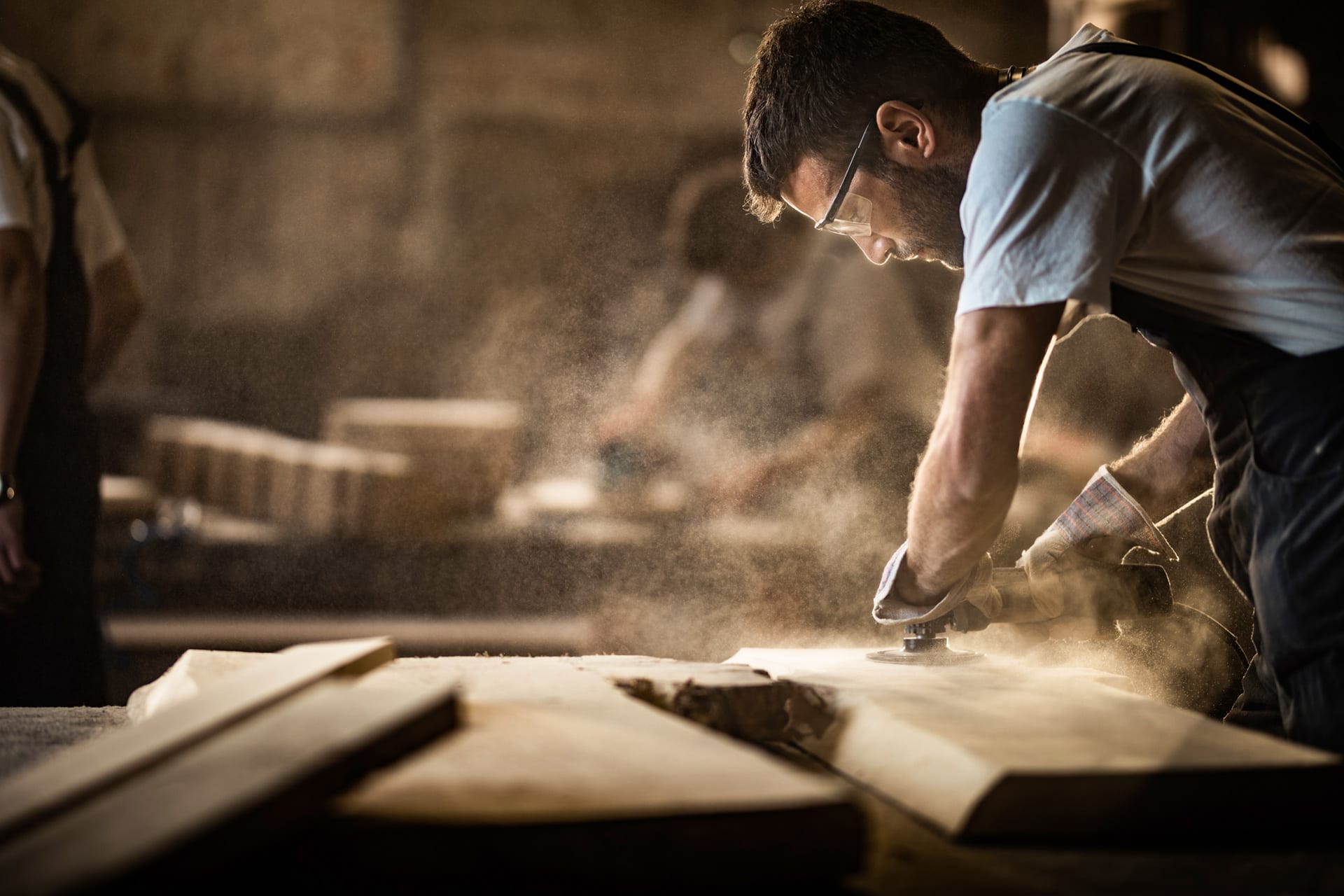 Woodworker sanding a custom cabinet